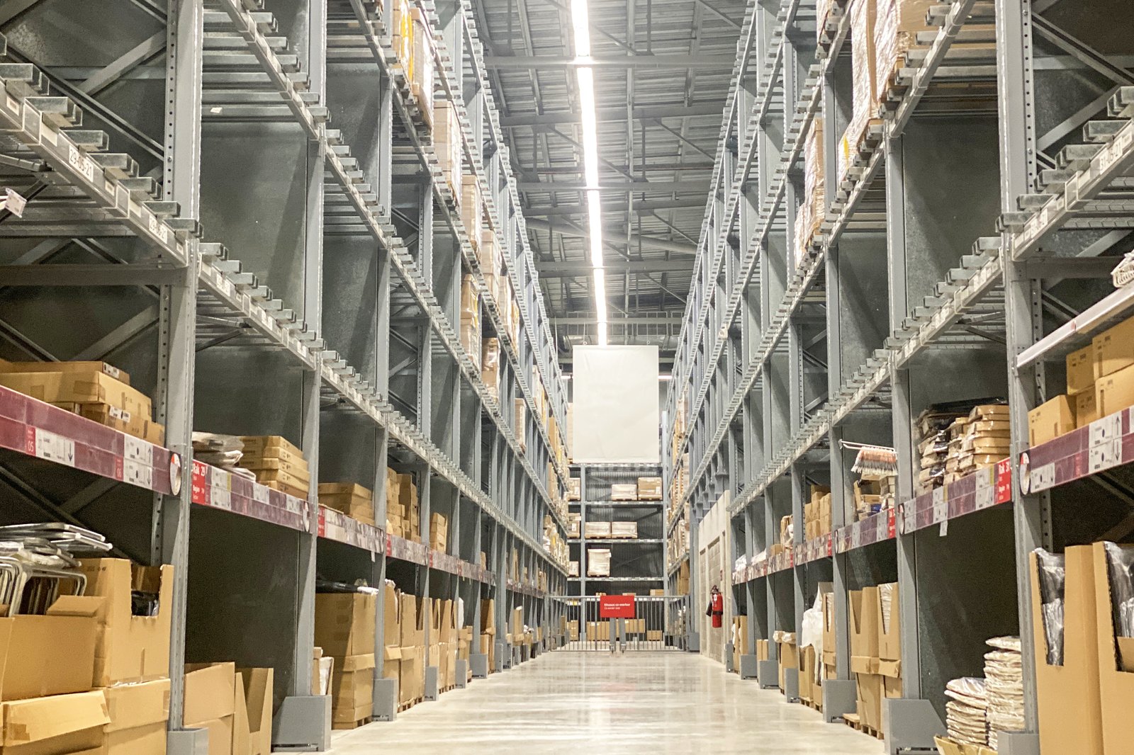 Large warehouse interior with tall pallet racks and long aisles that needs several Marvelmind submaps for coverage